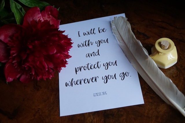 A note with a pen and a flower on a table- God's promises