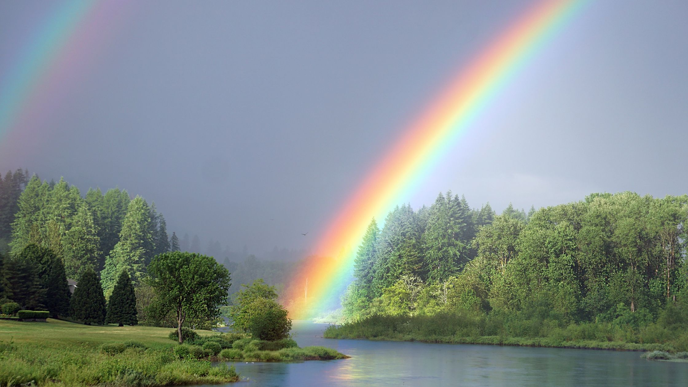 Resilience and faith- rainbow over peaceful river