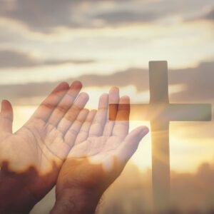 Hands reaching toward a cross with a radiant sunset in the background, symbolizing the miraculous power of Jesus to transform lives and offer hope