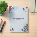 Medication Tracker Log Book by Angeline P. Utile on a wooden desk with pens, notebook, paperclips, and a potted plant — cover features medical illustrations like pills, syringe, and stethoscope