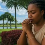 Woman praying outdoors, seeking guidance on how to pray when you don’t know what to say, with a peaceful park and lake in the background.